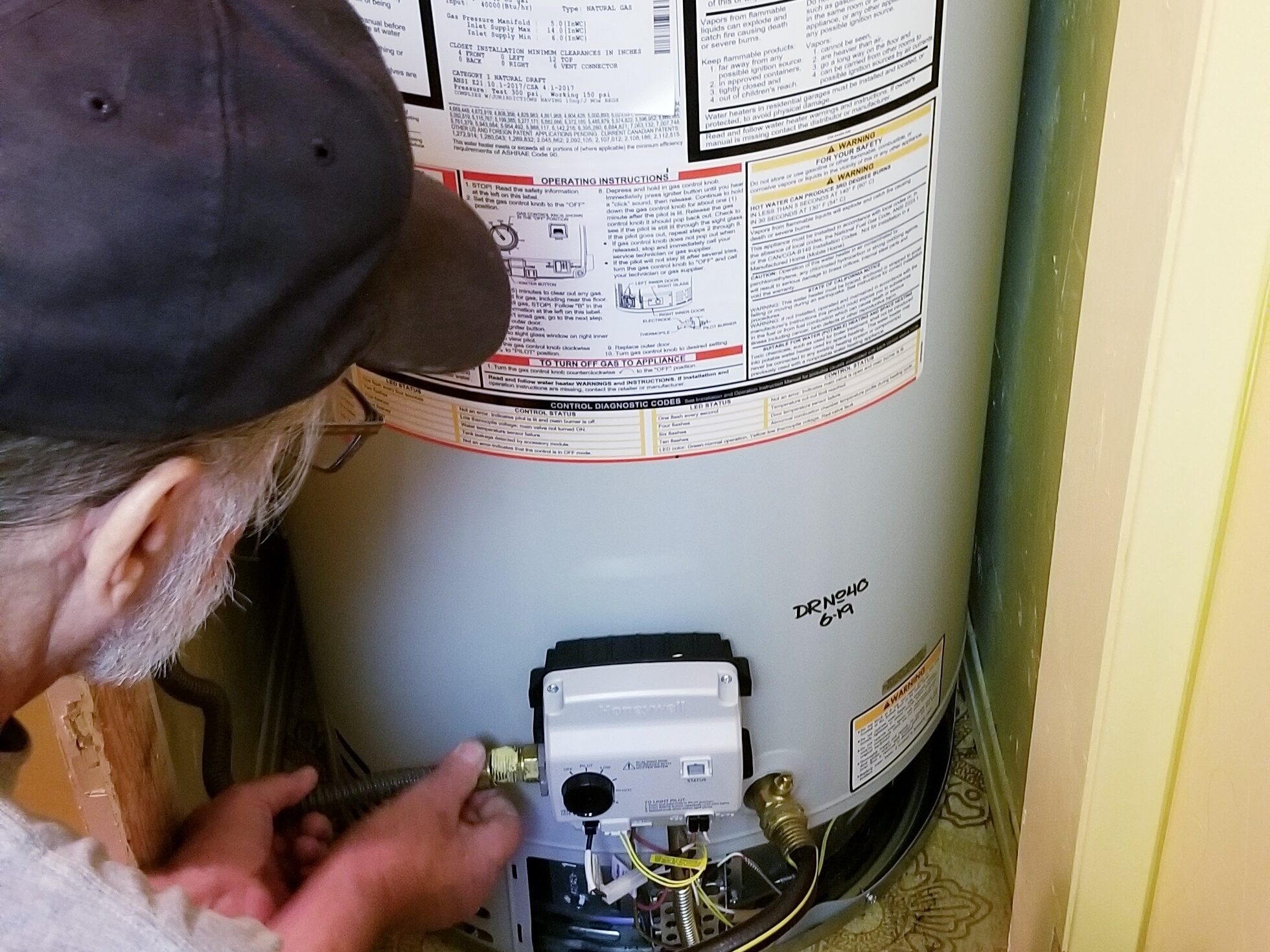 professional water heater technician inspecting a tank water heater