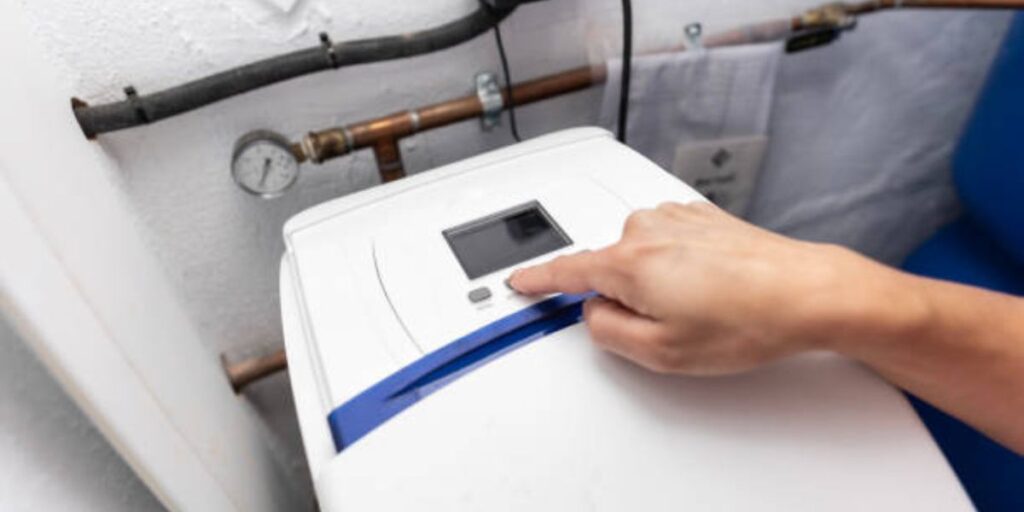 Home water softener system installed in utility room with technician checking performance levels | How Can You Tell if a Water Softener Is Working
