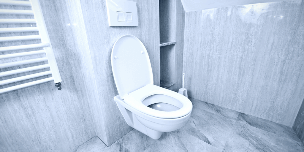 Modern bathroom with a wall-mounted toilet in a tiled space representing plumbing issues such as a gurgling toilet and drainage problems.
